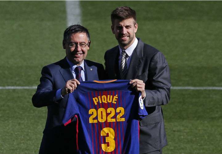 Gerard Piqué (dcha.) posa con el presidente del FC Barcelona, Josep María Bartomeu, durante la renovación de su contrato con el club azulgrana. Foto AP