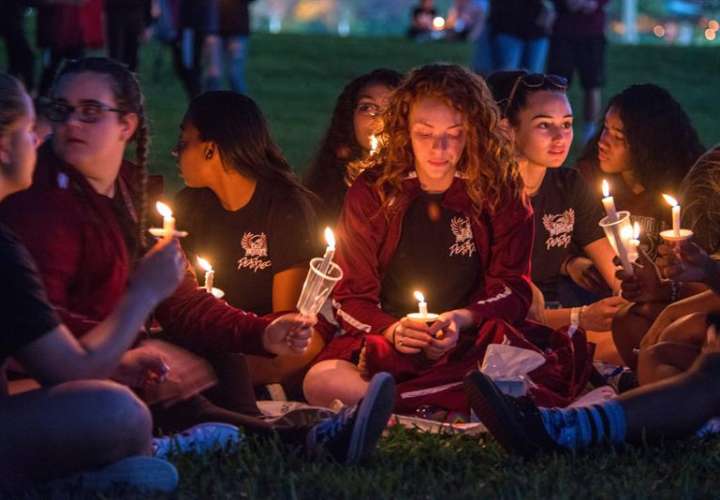 Miles de personas participan en la vigila en recuerdo de las 17 víctimas mortales de la matanza perpetrada este miércoles por Nikolas Cruz en la escuela secundaria Marjory Stoneman Douglas, en Pine Trails Park, Parkland, Florida. EFE