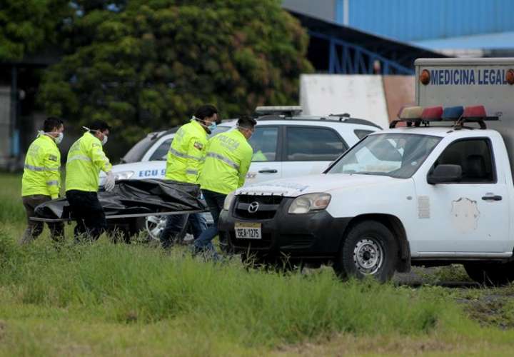 Policías ecuatorianos realizan el levantamiento del cadáver de una de las dos personas que fallecieron al caer presuntamente desde el tren de aterrizaje de un avión. EFE