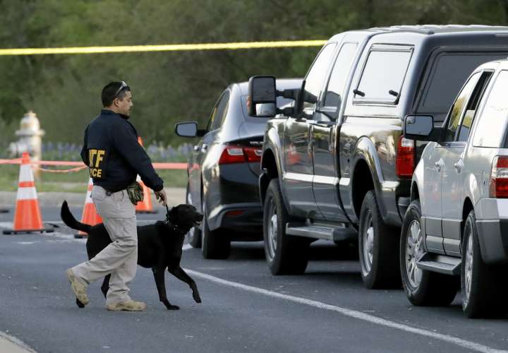 Un agente de la Oficina de Alcohol, Tabaco, Armas de Fuego y Explosivos trabaja con su perro cerca del sitio de la explosión mortal. Foto: AP