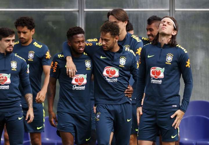 Los jugadores brasileños Fred (i) y Neymar (d) se abrazan durante una sesión de entrenamiento de su selección nacional./EFE