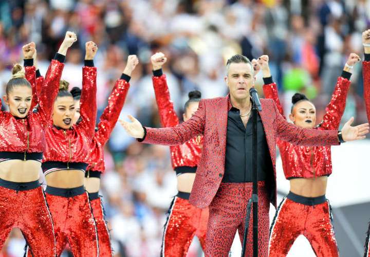 Robbie Williams saca dedo del medio a la cámara, en presentación del Mundial