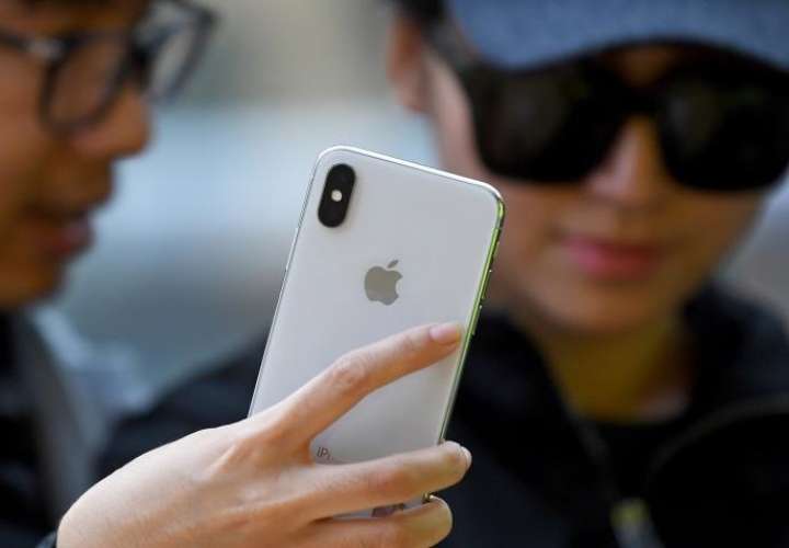 Fotografía de archivo tomada el 13 de noviembre de 2017 que muestra a una joven que observa el iPhone X tras su salida a la venta en una tienda Apple en Sídney (Australia). EFE