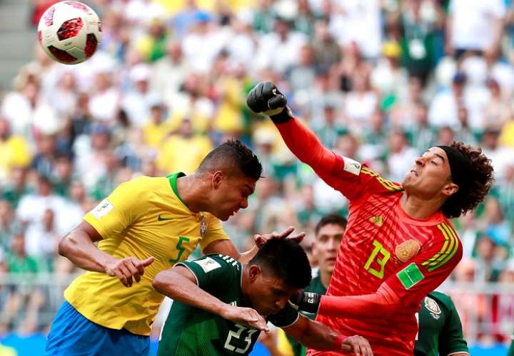 El portero mexicano Guillermo Ochoa despeja de puños un balón durante el partido Brasil-México./EFE
