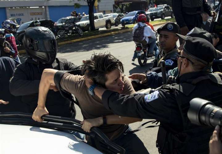 Policías detienen a un manifestante durante la marcha 