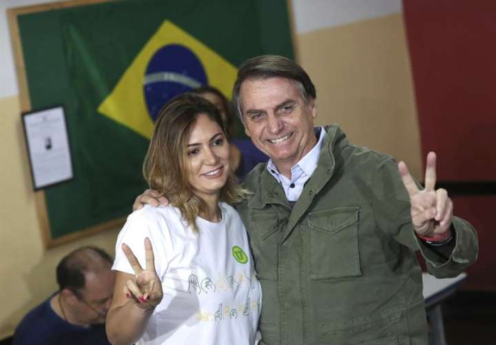El candidato ultraderechista Jair Bolsonaro, acompañado de su esposa, Michelle, tras vota en una area militar en la zona norte de Río de Janeiro. EFE