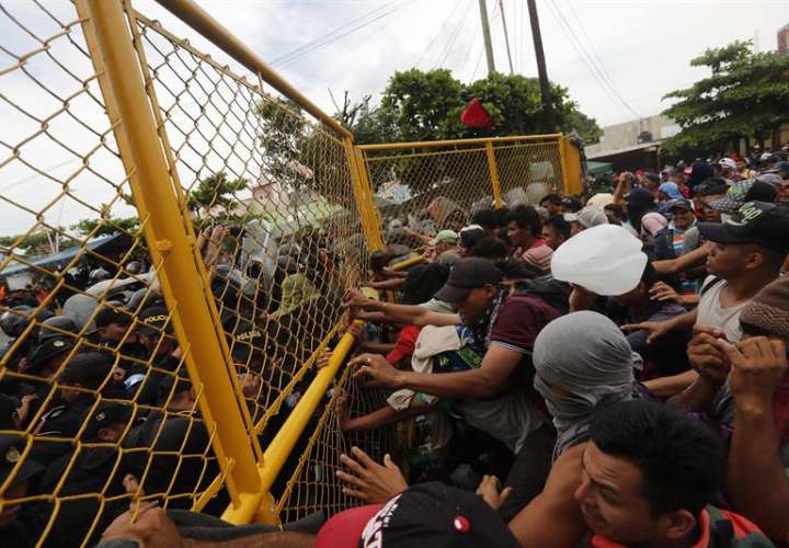 Cientos de migrantes centroamericanos que hacen parte de una segunda caravana rumbo a EE.UU intentan cruzar en el paso fronterizo entre México y Guatemala hoy, domingo 28 de octubre de 2018, en Tecún Umán (Guatemala). EFE