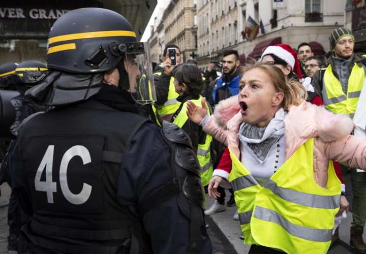 Una manifestante grita a un policía antidisturbios durante una manifestación de los 