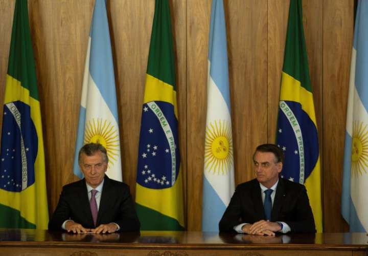 El presidente de Brasil, Jair Bolsonaro (d), y su homólogo argentino, Mauricio Macri (i), hablan en rueda de prensa tras la firma de actos, hoy en Brasilia (Brasil). EFE