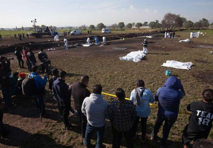 Expertos forenses registran la zona cerca de una toma clandestina de gasolina de Petróleos Mexicanos (Pemex) que explotó este sábado, en Tlahuililpan, Hidalgo (México). EFE