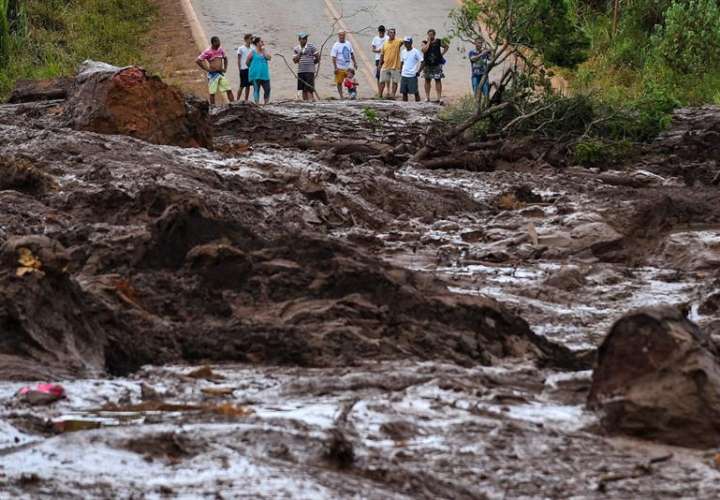 Pobladores observan este sábado el desastre causado por la rotura de una presa que contenía residuos minerales de la compañía Vale, en Brumadinho, municipio de Minas Gerais (Brasil). EFE