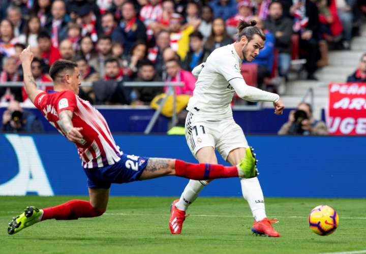 El delantero galés del Real Madrid Gareth Bale (d) y el defensa uruguayo del Atlético de Madrid José María Giménez durante el partido de la vigésimo tercera jornada de Liga que disputaron en el estadio Wanda Metropolitano de Madrid. EFE