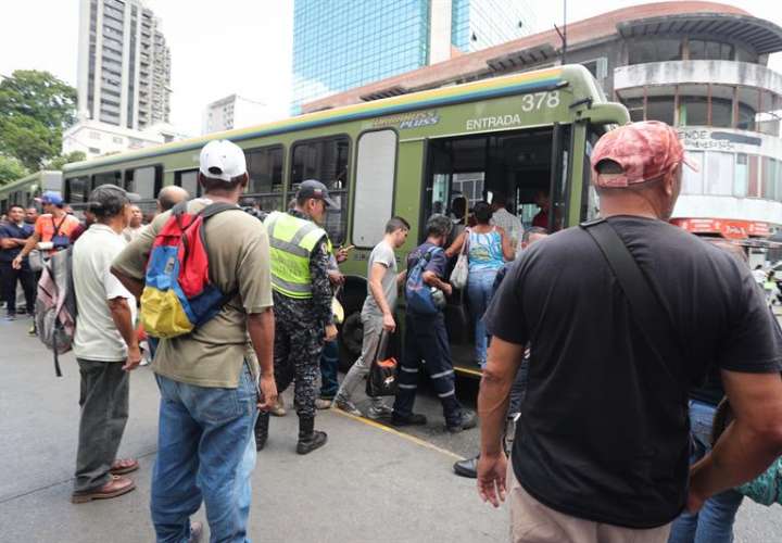 Un grupo de personas toma autobuses de servicio público hoy, jueves en Caracas. Los venezolanos reanudan sus actividades luego del fallo eléctrico que hace una semana afectó casi todo el país y por el que se paralizaron los servicios durante al menos 100 