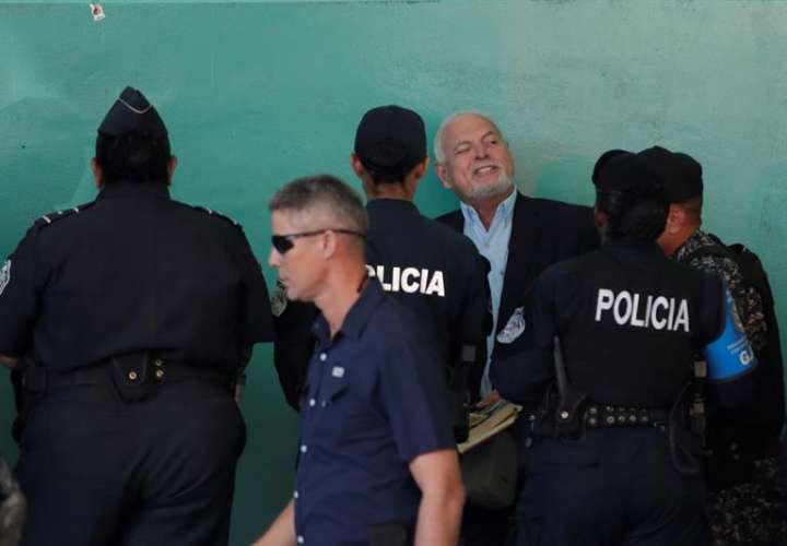 Unidades de la policía custodian al expresidente de Panamá, Ricardo Martinelli (c) hoy, viernes, a su llegada al juzgado del Sistema Penal Acusatorio en Ciudad de Panamá, para audiencia por supuestas escuchas. EFE
