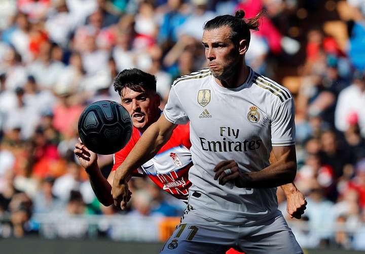 El jugador galés del Real Madrid, Gareth Bale (d), disputa el balón con el jugador del Granada Carlos Neva (i),. Foto: AP