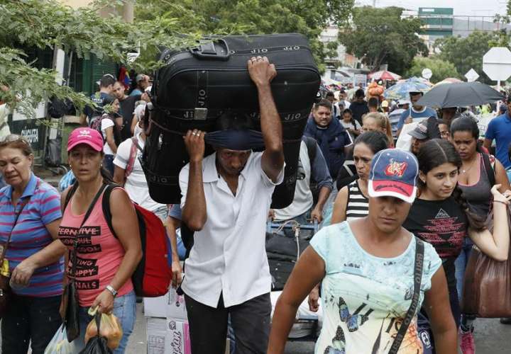 Ciudadanos venezolanos regresan con sus maletas llenas de provisiones por el puente internacional Simón Bolívar este sábado, en Cúcuta (Colombia). EFE
