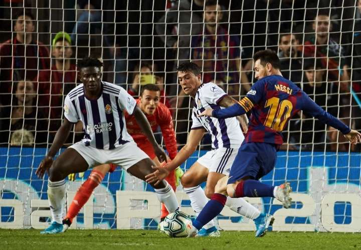 El delantero argentino del FC Barcelona, Leo Messi (d), se dispone a golpear el balón ante los defensores del Valladolid. Foto: AP