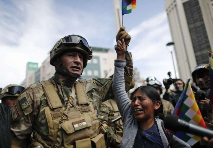 Una mujer llora frente a los soldados que custodian una calle durante una marcha de simpatizantes del ex presidente Evo Morales en el centro de La Paz. AP