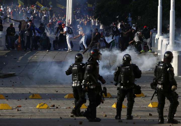 Manifestantes enfrentan a la Policía durante el desarrollo de las protestas y movilizaciones por el denominado Paro Nacional este jueves, en Cali (Colombia). EFE