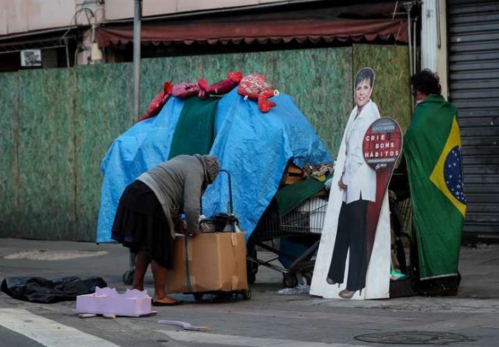 En la imagen, dos habitantes de calle mueven algunas de sus pertenencias, en Sao Paulo (Brasil). EFE