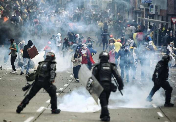 Manifestantes se enfrentan a integrantes del Escuadrón Móvil Antidisturbios (ESMAD) de la Policía colombiana, en la Loma de la Cruz en Cali (Colombia). EFE