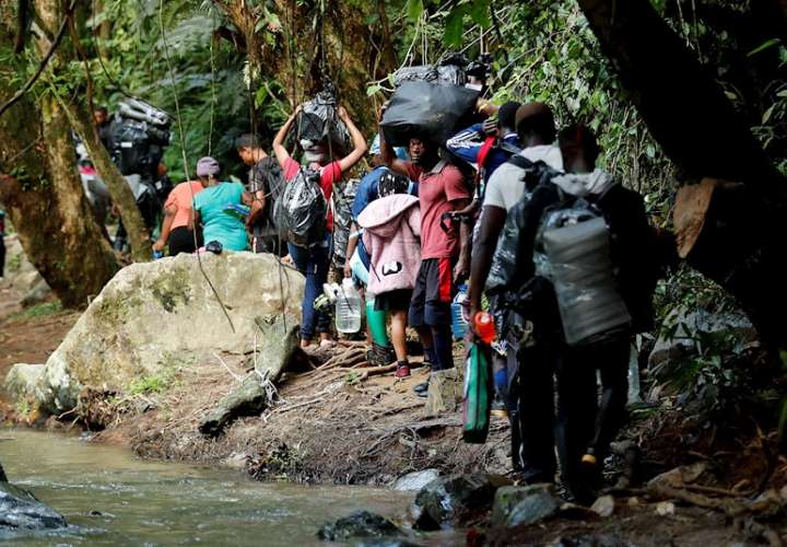 La imagen muestra a migrantes haitianos en su camino hacia Panamá por el Tapón del Darién en Acandi (Colombia). EFe
