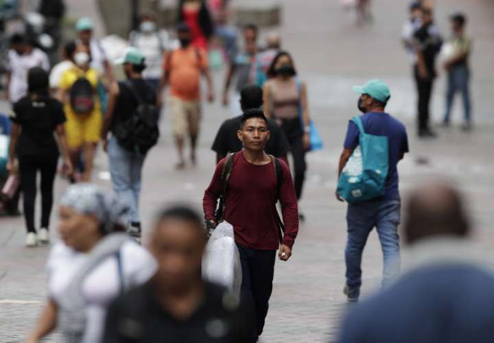 Personas caminan sin mascarillas en la Avenida Central en Ciudad de Panamá. EFE