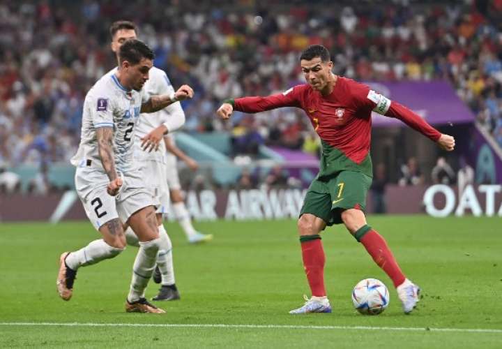 José María Giménez (izq.), de Uruguay, defiende a Cristiano Ronaldo de Portugal. Foto: EFE