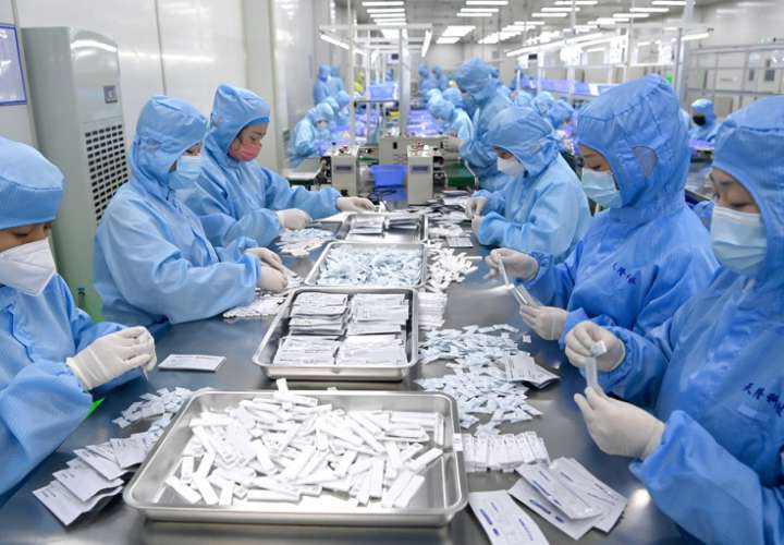 Los empleados producen kits de prueba de antígeno COVID-19 en una empresa de equipos médicos en Xi'an, provincia de Shaanxi, noroeste de China. EFE