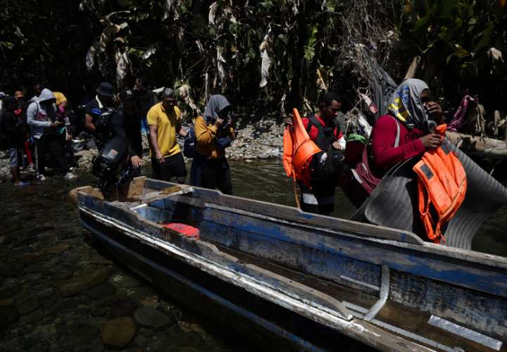 Personas migrantes esperan en la selva para ser trasladados en canoa desde la Quebrada León hasta a la comunidad de Bajo Chiquito. EFE