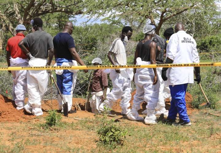 Detectives de homicidios de Kenia y expertos forenses de la Dirección de Investigaciones Criminales (DCI), examinan los cuerpos exhumados de varias fosas comunes poco profundas de presuntos miembros de un culto cristiano después de morirse de hambre. EFE