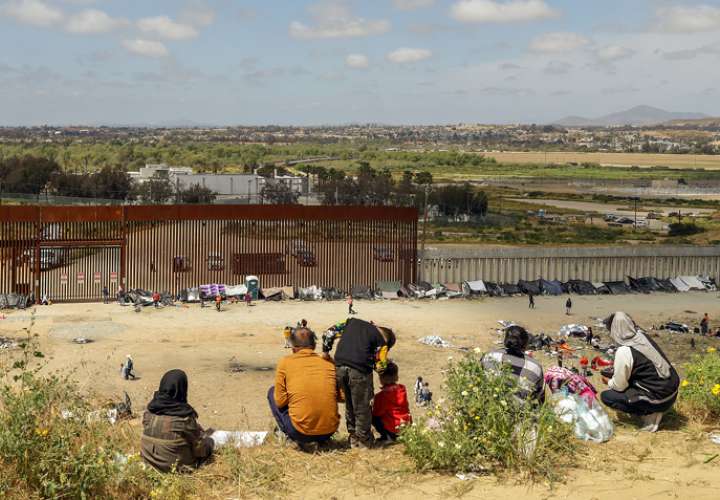 Fotografía general donde se observa a migrantes en un campamento junto al muro fronterizo, en Tijuana, Baja California (México). EFE