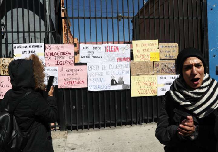 Varias personas protestan en contra de la Iglesia católica pegando carteles en las puertas del seminario San Jerónimo, en La Paz (Bolivia). EFE