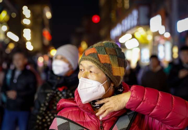 Una mujer usa una máscara KN95 en un distrito comercial de Beijing, China. EFE