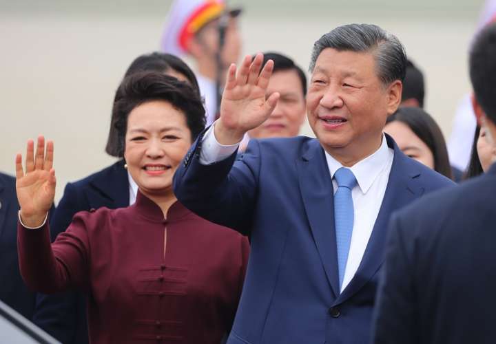El presidente chino, Xi Jinping (D), y su esposa, Peng Liyuan (I), aludan al llegar al aeropuerto internacional de Noi Bai,en Hanoi. EFE