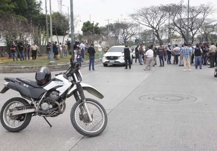 Vistas del momento cuando policías investigaban el vehículo con impactos de bala en el que se encontraba el fiscal César Suárez al ser asesinado. EFE