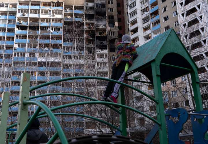 Fotografía tomada en Kiev, Ucrania, desde un parque infantil en la que una niña observa los apartamentos quemados.