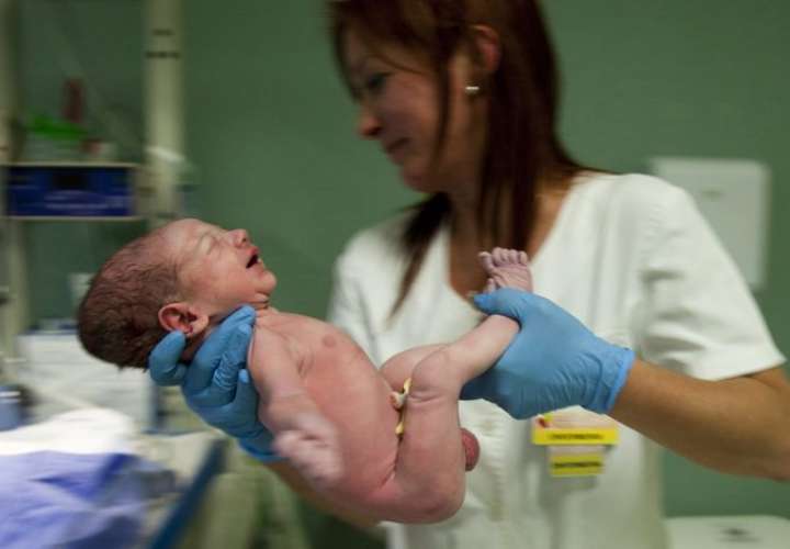 Una enfermera sostiene un bebé recién nacido. EFE / Archivo