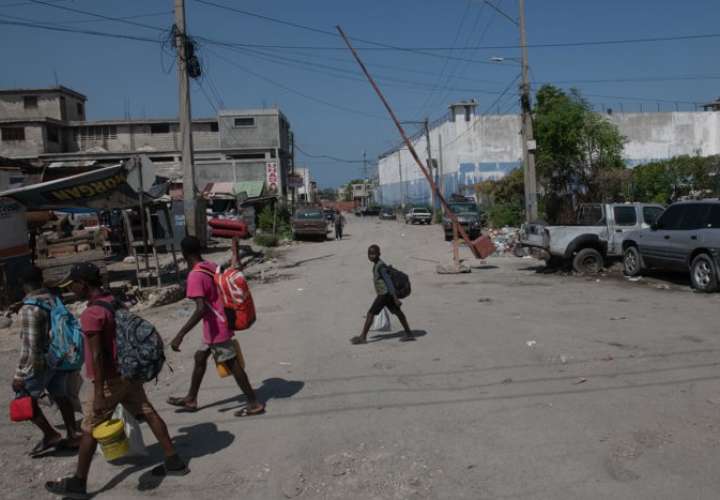 Personas caminan por una de las calles próximas a la prisión nacional este lunes, en Puerto Príncipe (Haití). EFE