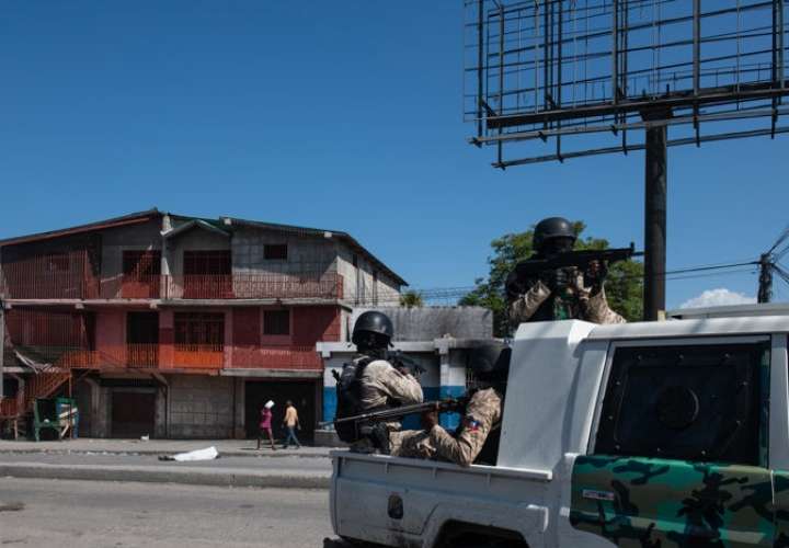 Policías patrullan una calle cercana a la comisaría de Carrefour Aéroport, que fue incendiada por miembros de pandillas, en Puerto Príncipe (Haití). EFE