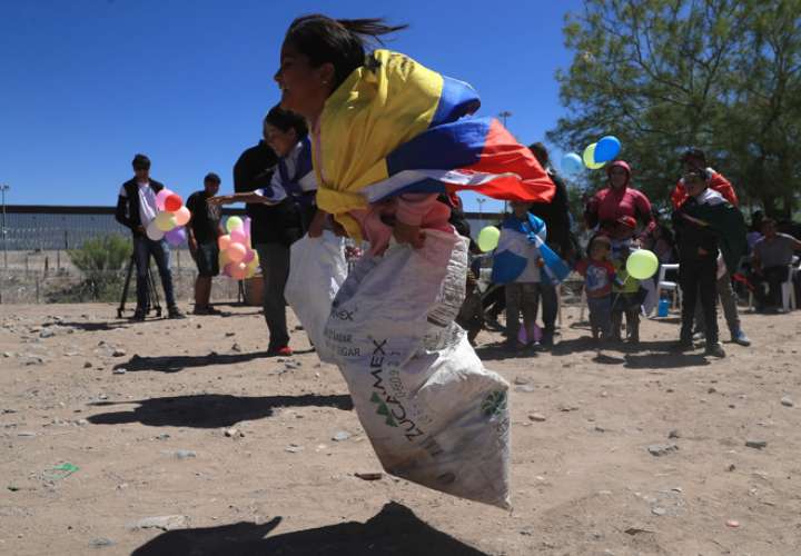 Integrantes del colectivo 'Ángeles Mensajeros' celebraron a los niños en su día el pasado 1 de mayo, en la frontera con Estados Unidos, en Ciudad Juárez (México). EFE