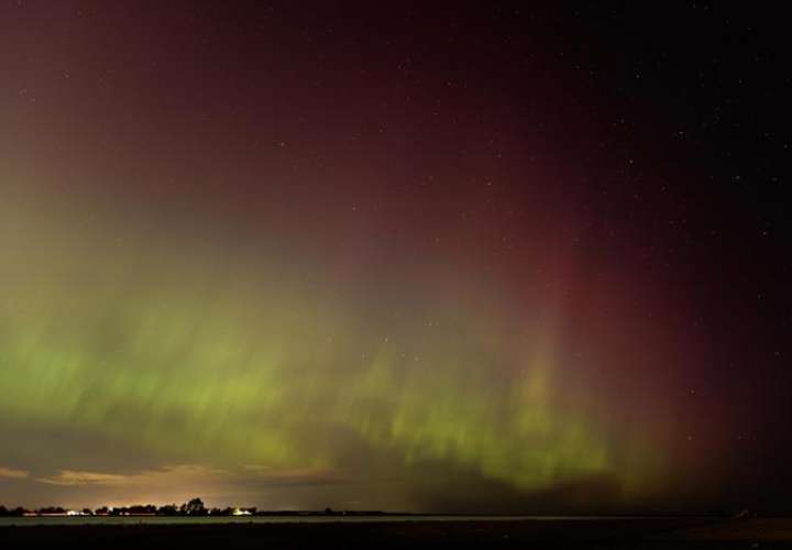 La aurora boreal se ilumina en el cielo nocturno sobre Plum Island y la desembocadura del río Merrimack, en Newburyport, Massachusetts, EE.UU. EFE