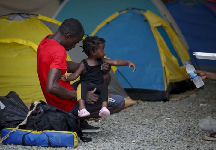 Un migrante descansa con una niña en la estación de recepción migratoria de Lajas Blancas.EFE