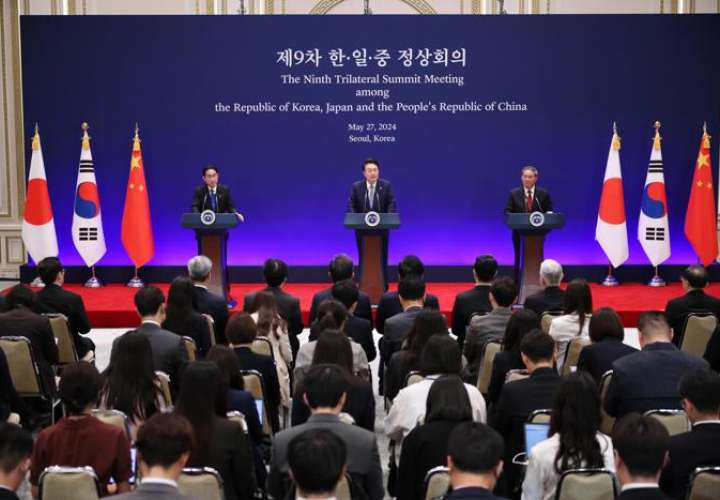 El presidente surcoreano, Yoon Suk-yeol (C), habla mientras el primer ministro japonés, Fumio Kishida (I), y el primer ministro chino, Li Qiang (D) escuchan. EFE