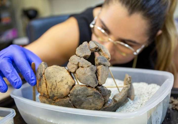 Raiza Erlenbaugh, técnica de laboratorio de arqueología de STRI, utiliza arena y palillos para equilibrar los tiestos mientras se seca el pegamento.  Crédito Jorge Aleman/ STRI