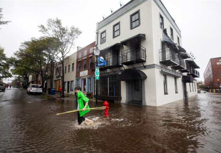 Fotografía tomada el pasado 14 de septiembre en la que se registró a varios afectados, al caminar por una calle inundada en Wilmington (Carolina del Norte, EE.UU.), tras el paso del huracán Florence. EFE/Archivo