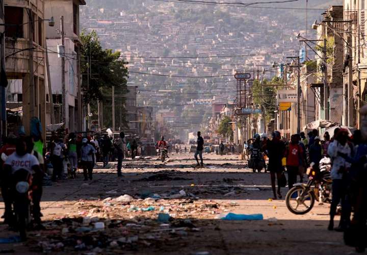 Varias personas caminan por una importante avenida sin flujo de vehículos durante una segunda jornada de protestas, hoy, en Puerto Príncipe (Haití). EFE