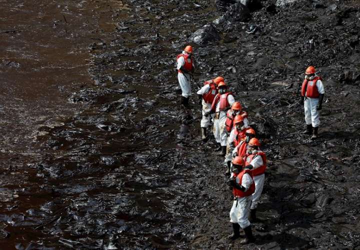 Un grupo de trabajadores fue registrado este martes al realizar labores de limpieza en las playas de Ventanilla (Perú), donde un derrame de petróleo ha contaminado la zona y ha afectado los ecosistemas nativos. EFE