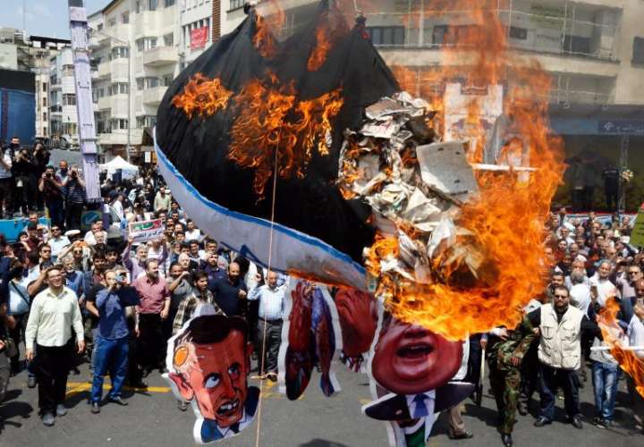 Iraníes queman la bandera israelí durante una protesta en Teherán (Irán), este viernes. EFE