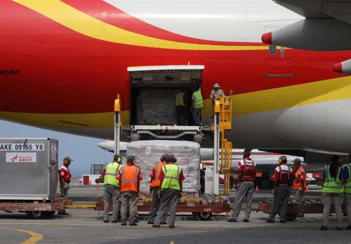 Personal descarga un avión proveniente de China que trae materiales médicos descartables, este viernes en el Aeropuerto Internacional Simón Bolívar, en Maiquetía (Venezuela). EFE